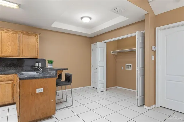 a kitchen with a stove a refrigerator a sink dishwasher with a dining table and chair