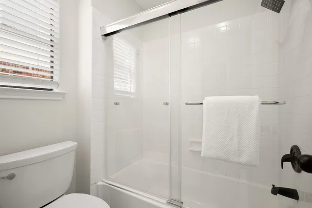a bathroom with a granite countertop sink two mirror and a shower