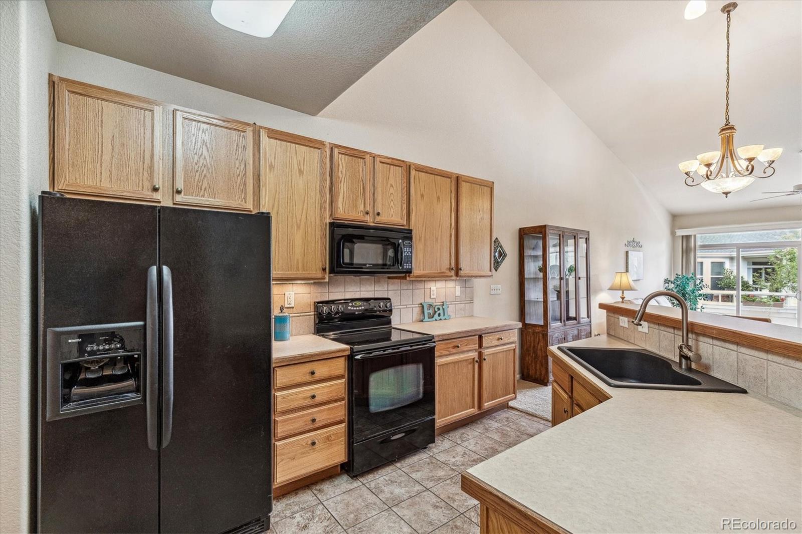 6596 South Reed Way, Unit B Littleton, CO 80123 - Photo 11 of 22 a kitchen with stainless steel appliances a refrigerator stove microwave and sink