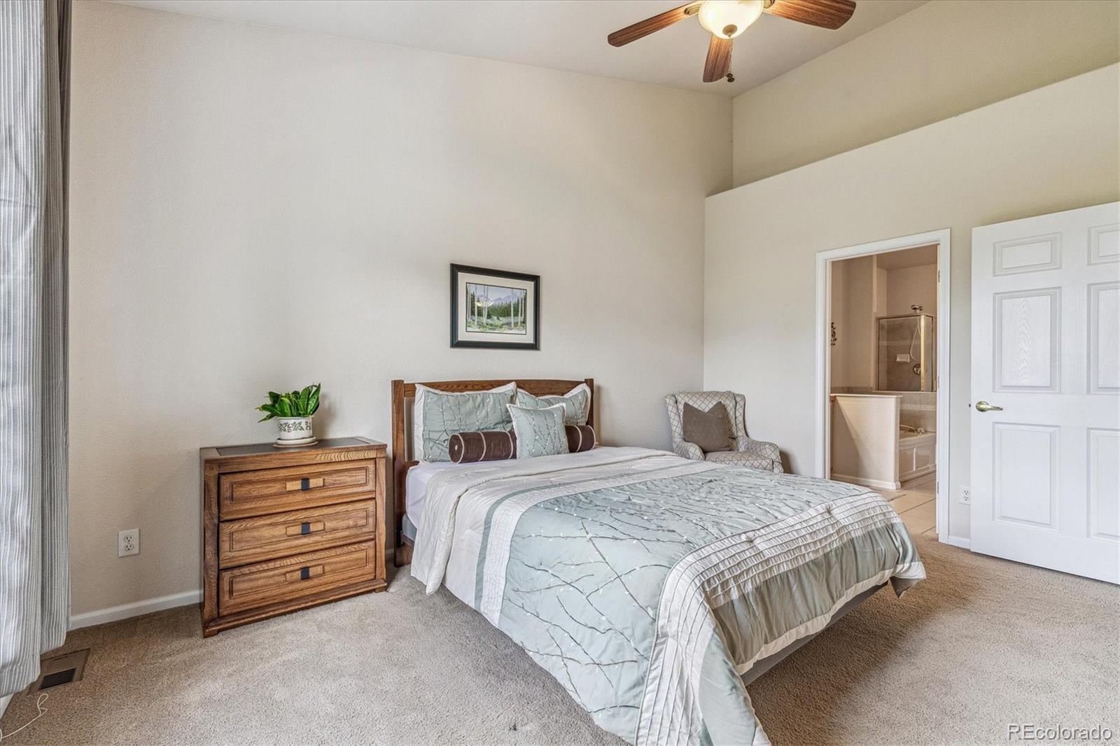 6596 South Reed Way, Unit B Littleton, CO 80123 - Photo 13 of 22 a bedroom with a bed and a chandelier