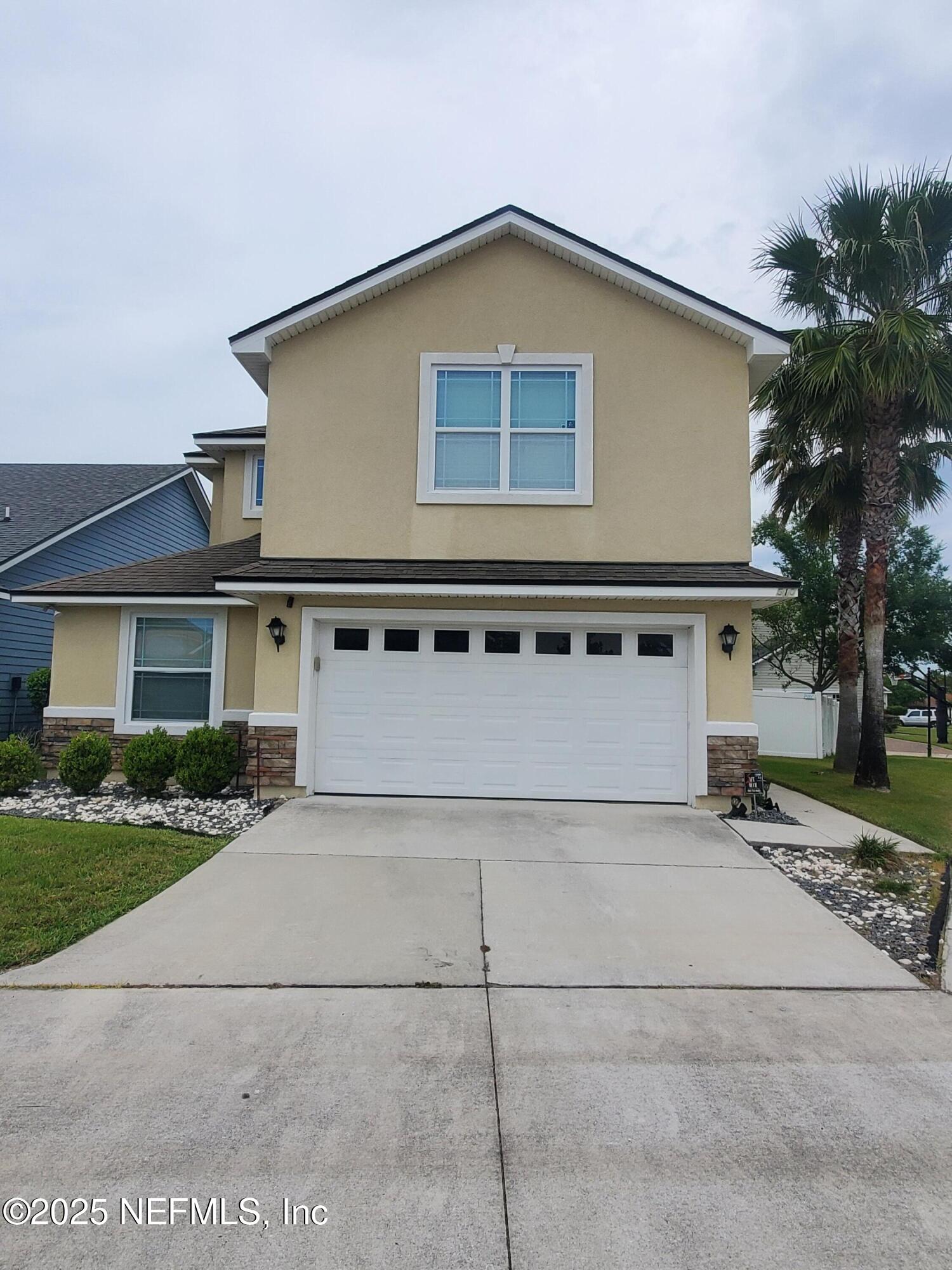 a front view of a house with a garden and garage