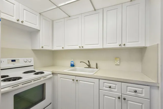 a kitchen with white cabinets and white appliances