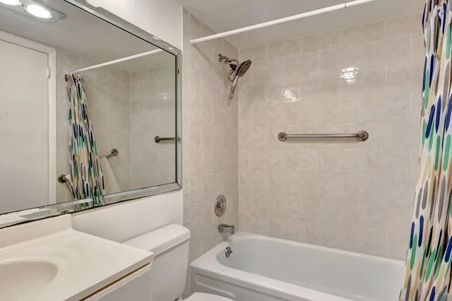 a bathroom with a tub shower sink and vanity