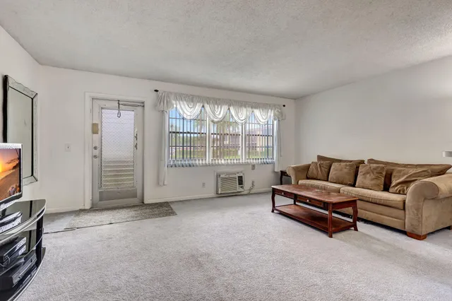 a living room with furniture a flat screen tv and a window