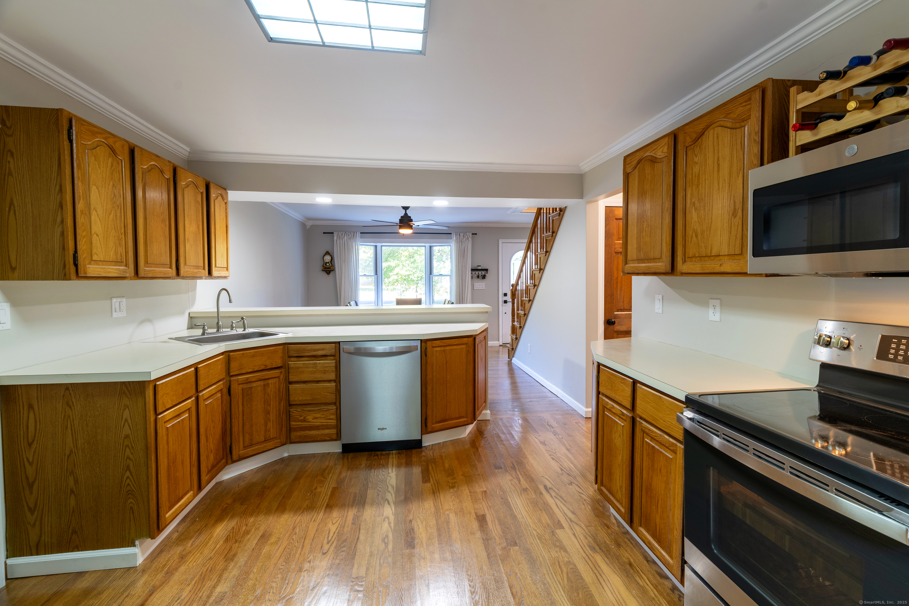 48 Quailcrest Road East Lyme, CT 06333 - Photo 13 of 31 a kitchen with stainless steel appliances granite countertop a stove a sink dishwasher and a microwave oven with wooden floor