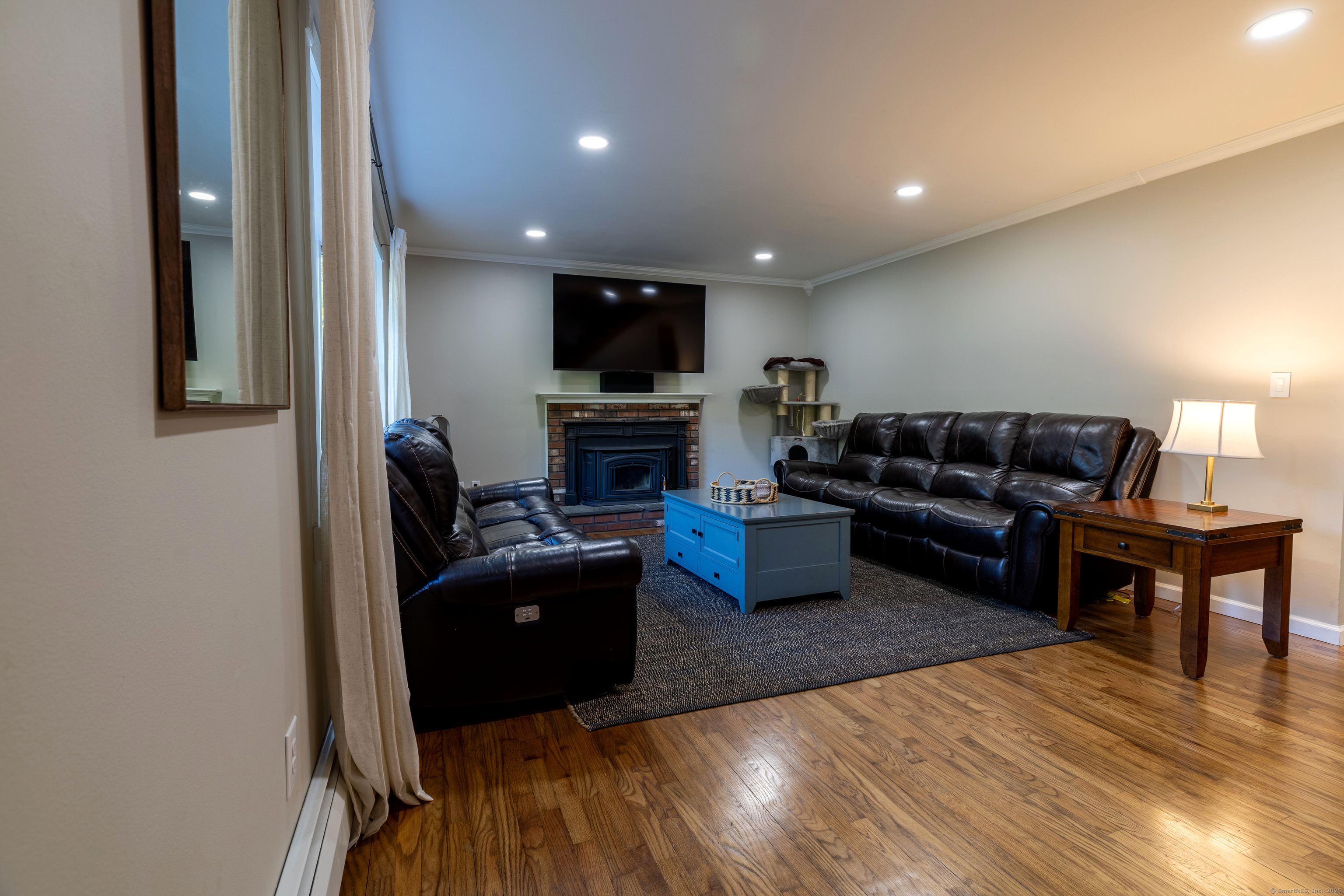 48 Quailcrest Road East Lyme, CT 06333 - Photo 8 of 31 a living room with furniture a flat screen tv and a fireplace