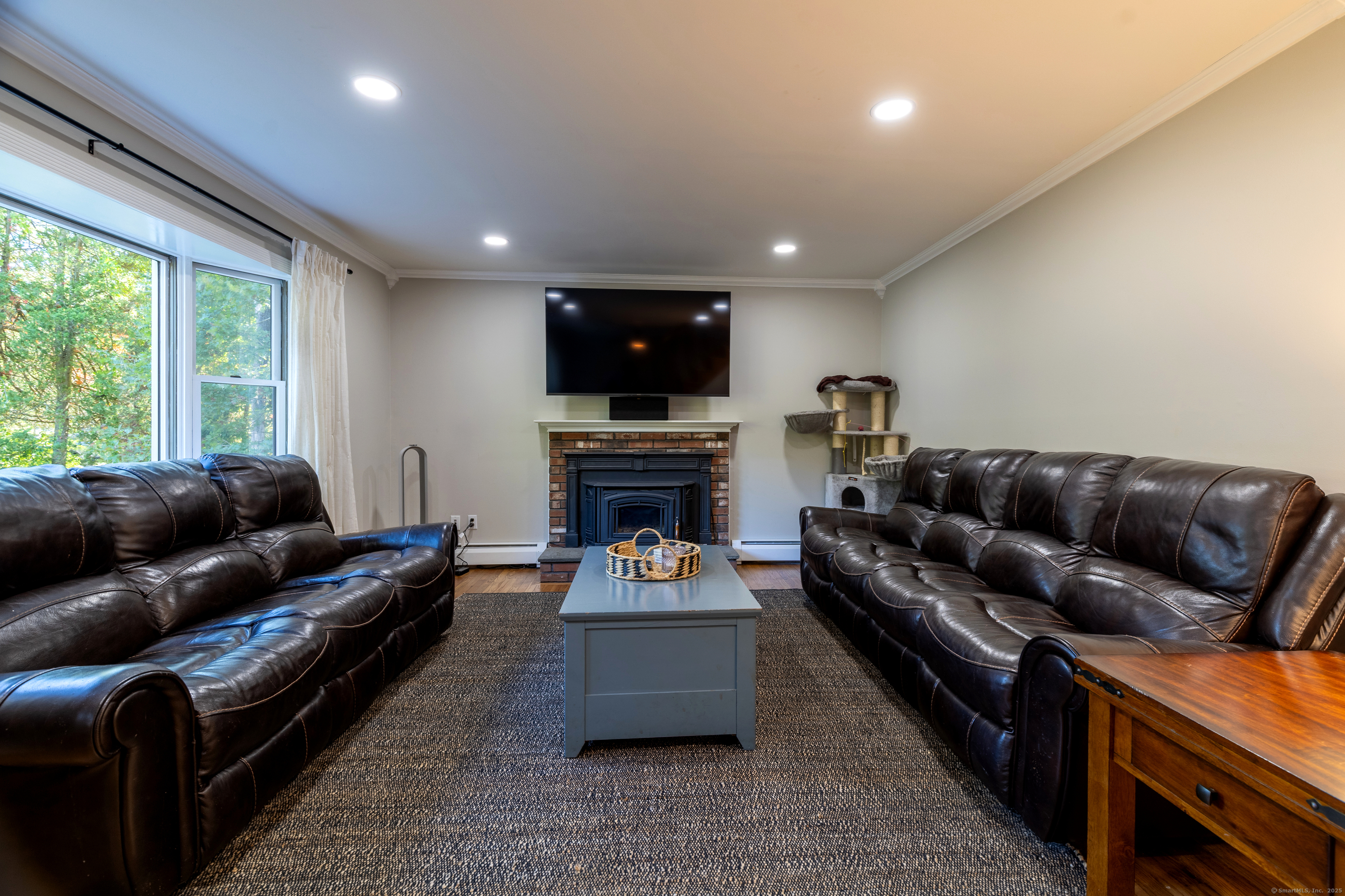 48 Quailcrest Road East Lyme, CT 06333 - Photo 9 of 31 a living room with furniture a fireplace and a flat screen tv