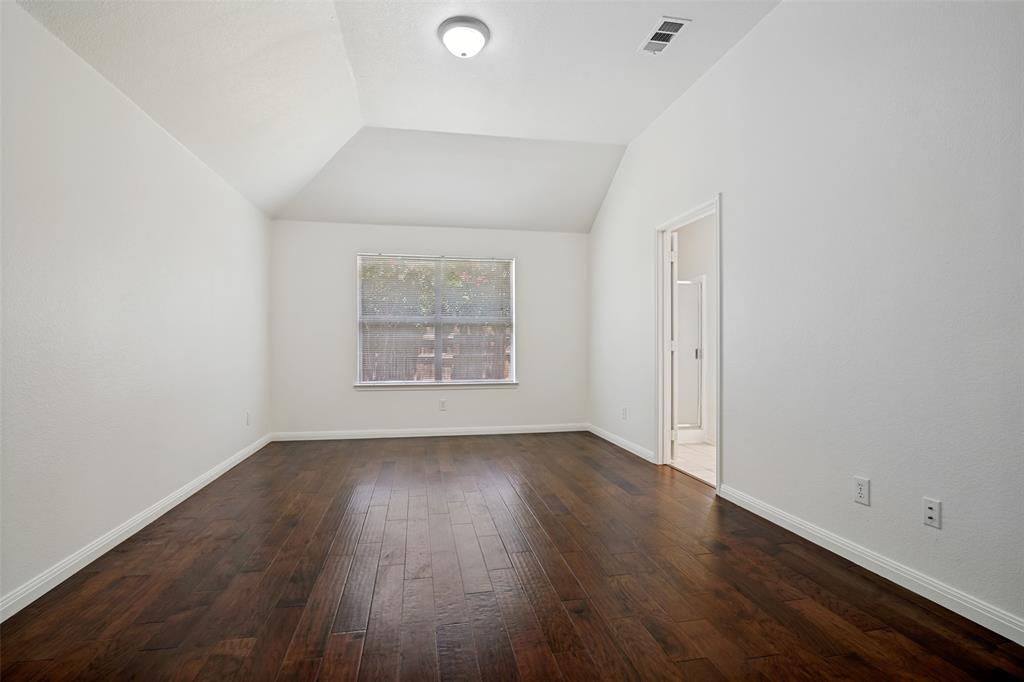 3111 Creekside Drive Sachse, TX 75048 - Photo 13 of 25 Spacious interior featuring wood-finish flooring, vaulted ceiling, and ample natural light from the window
