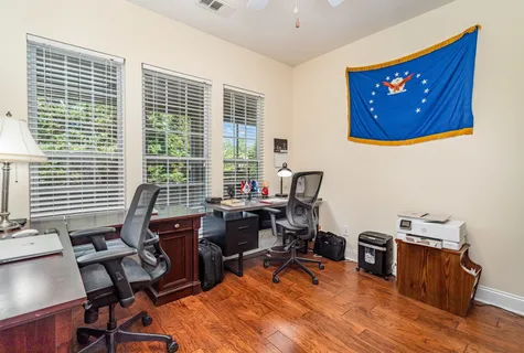 a view of a workspace with furniture and a window