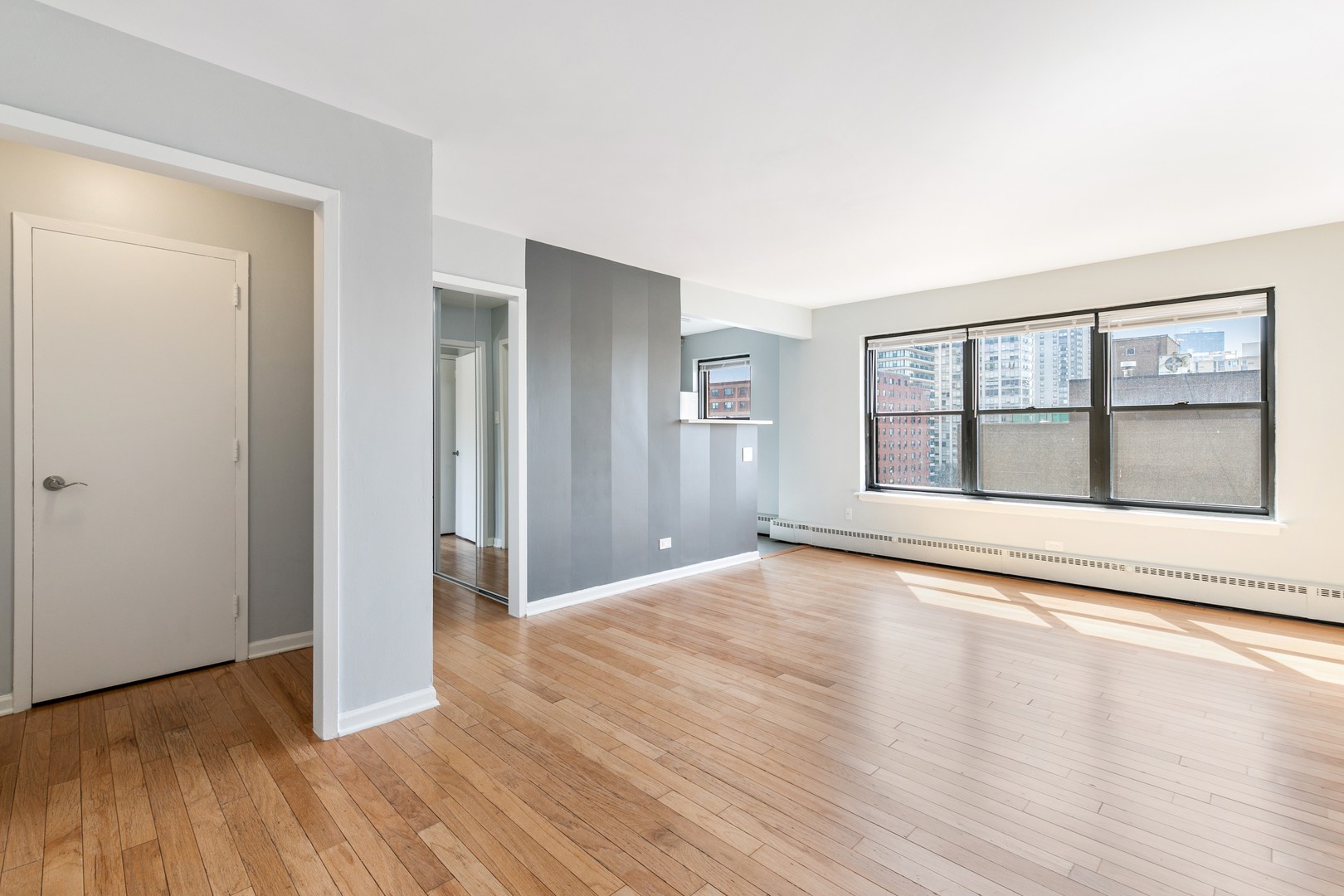 5858 North Sheridan Road, Unit 904 Chicago, IL 60660 - Photo 2 of 15 a view of an empty room with wooden floor and a window