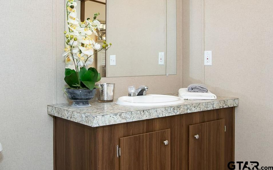 357 Oilfield Road Texarkana, TX 75501 - Photo 13 of 20 a bathroom with a granite countertop sink a vanity and a mirror