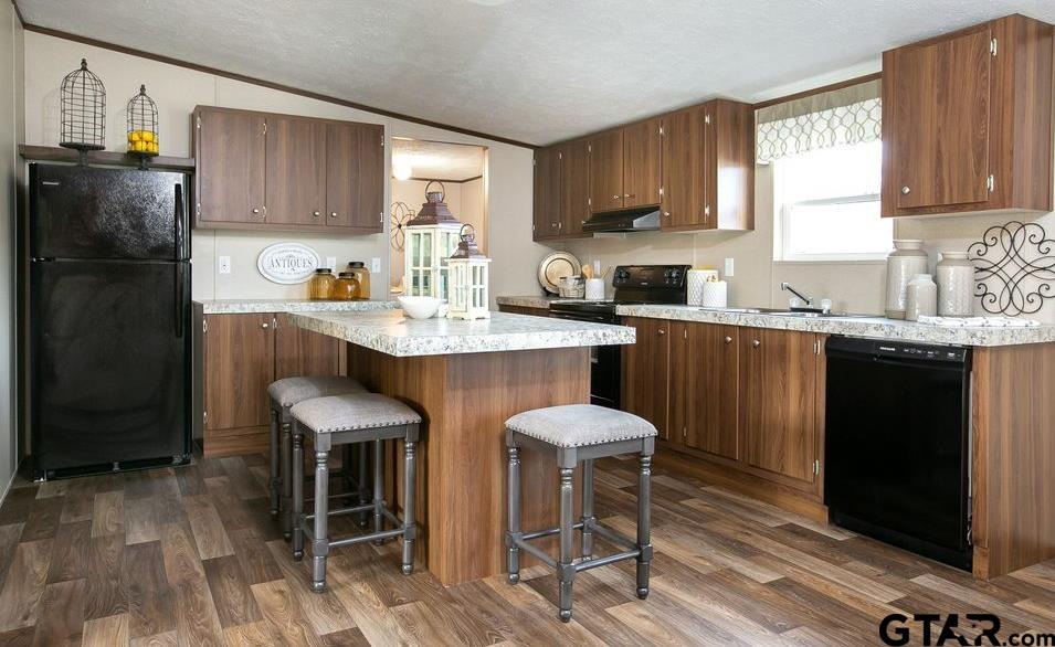 357 Oilfield Road Texarkana, TX 75501 - Photo 6 of 20 a kitchen with stainless steel appliances granite countertop a table chairs sink refrigerator and cabinets
