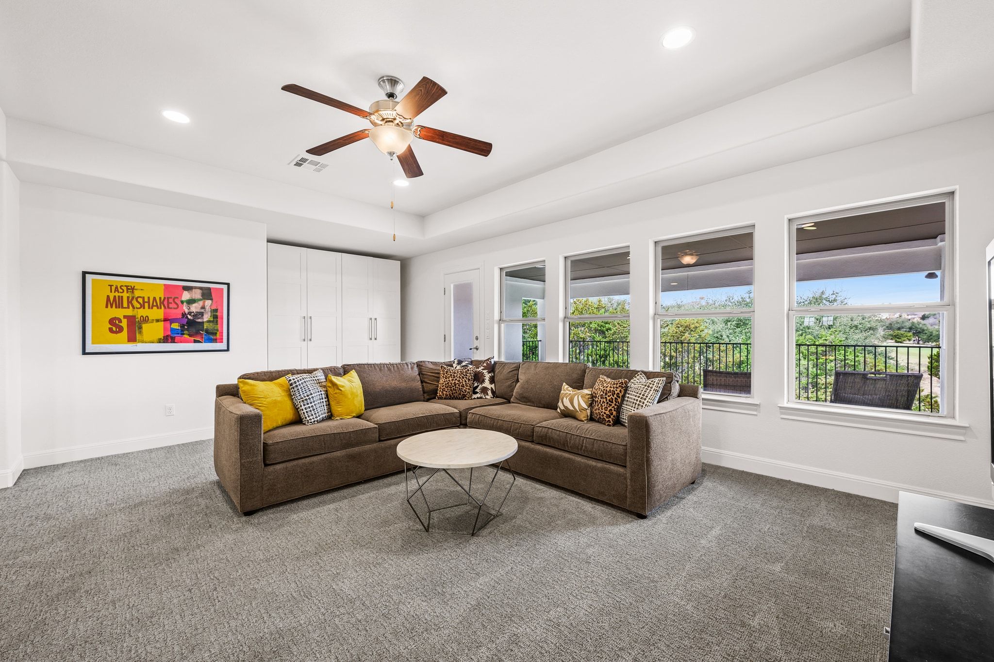 4609 Gallego Circle Austin, TX 78738 - Photo 18 of 40 Upstairs living area with a raised ceiling, carpeted floors, ceiling fan, and recessed lighting. It has access to a second-story balcony that overlooks the pool and Falconhead golf course.