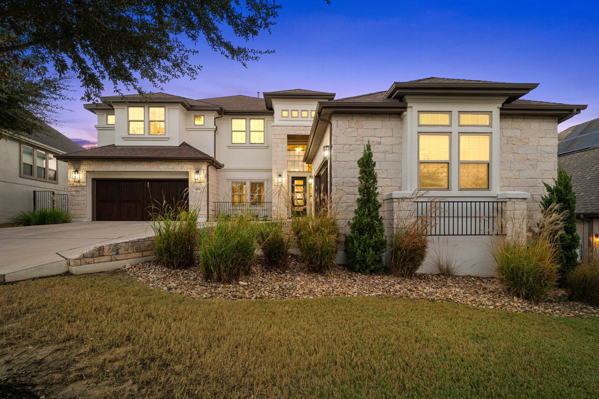 4609 Gallego Circle Austin, TX 78738 - Photo 2 of 40 Prairie-style home featuring stone siding, driveway, a front lawn,
