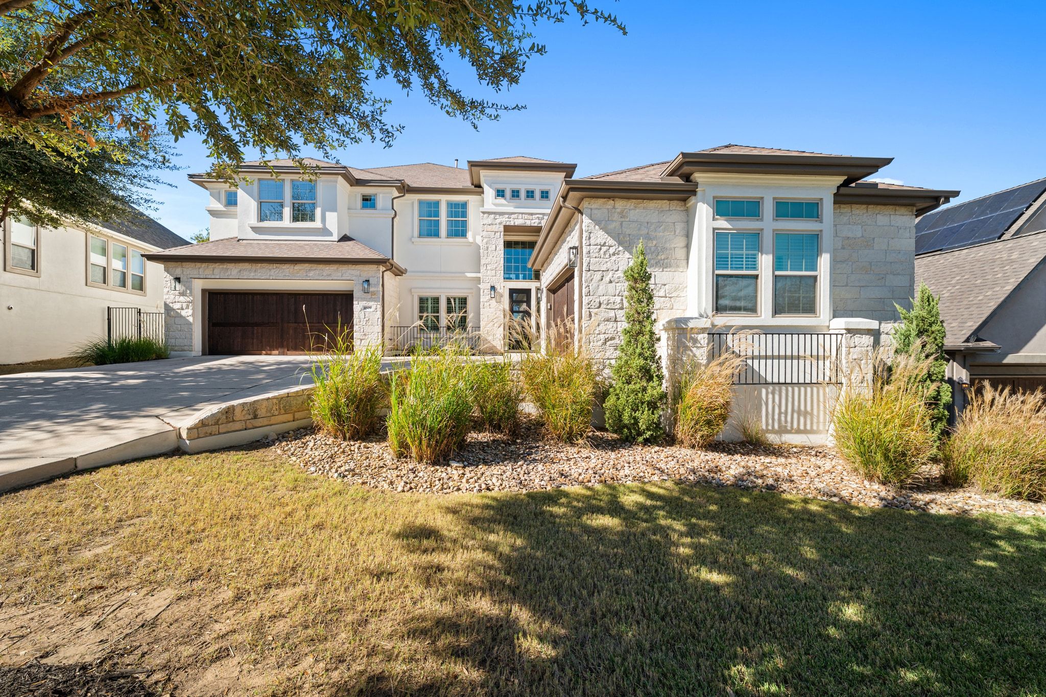 4609 Gallego Circle Austin, TX 78738 - Photo 38 of 40 Prairie-style house featuring concrete driveway, stone siding, and an attached garage