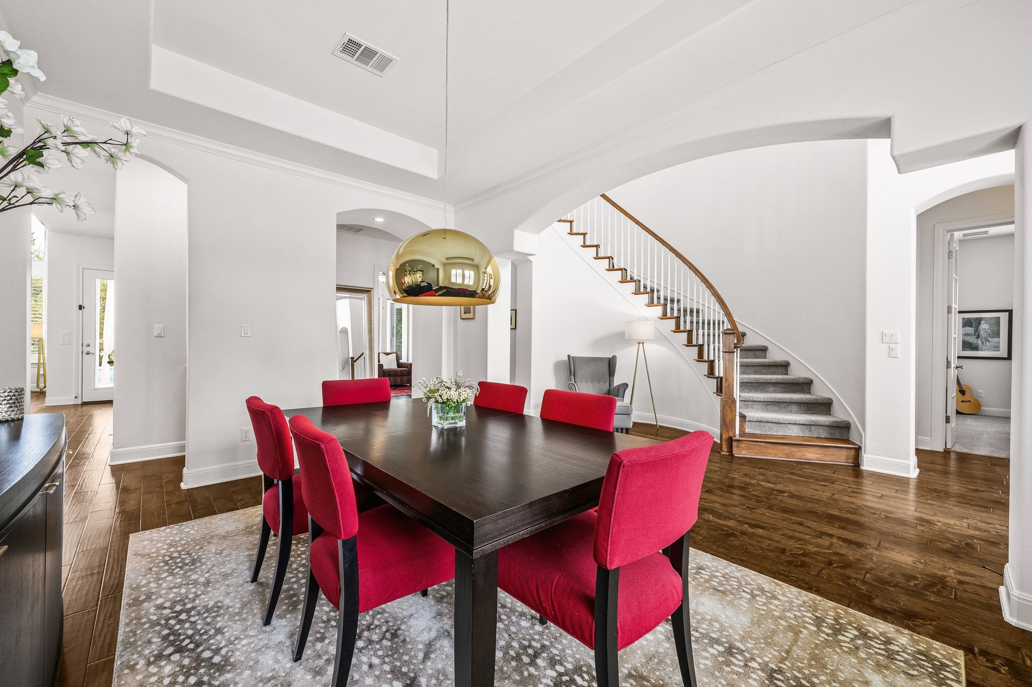 4609 Gallego Circle Austin, TX 78738 - Photo 4 of 40 Dining area featuring arched walkways, stairway, a raised ceiling, and dark wood finished floors