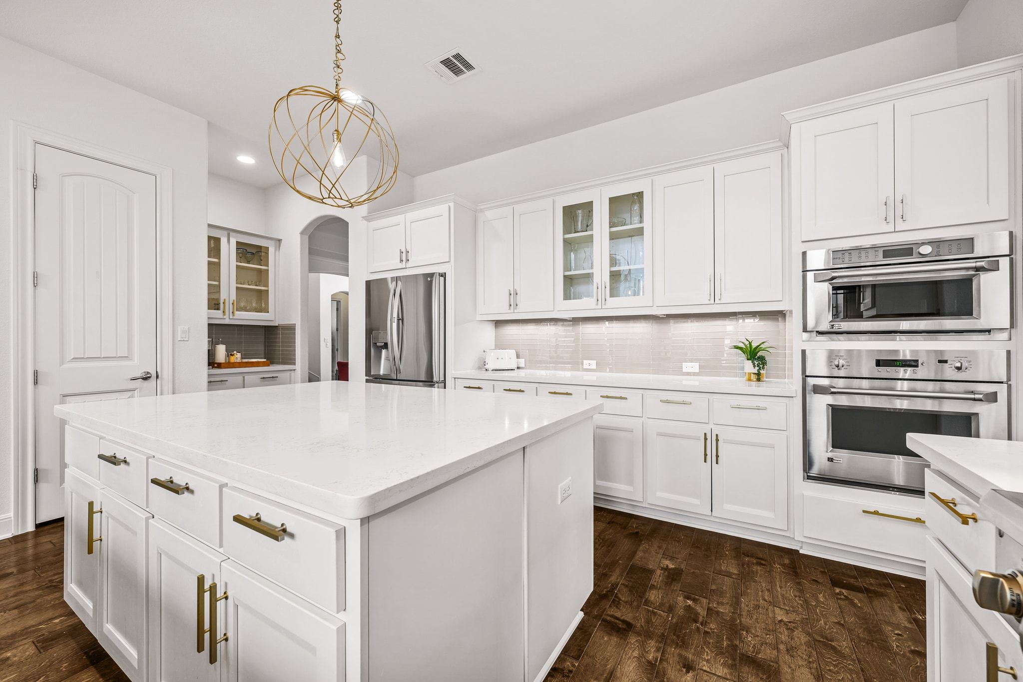 4609 Gallego Circle Austin, TX 78738 - Photo 6 of 40 Kitchen featuring glass insert cabinets, white cabinets, a kitchen island, pendant lighting, and recessed lighting