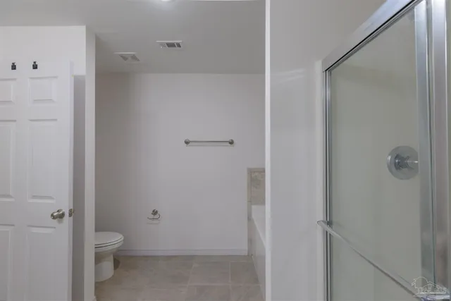 a bathroom with a granite countertop sink a toilet and shower