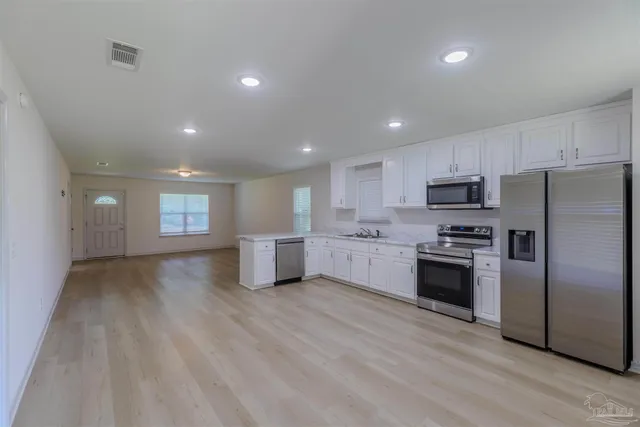 a kitchen with stainless steel appliances a refrigerator sink and stove
