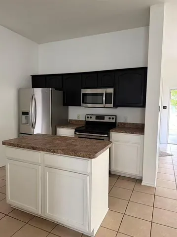 a view of an empty room with wooden floor and a fireplace