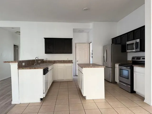 an empty room with wooden floor fireplace and windows