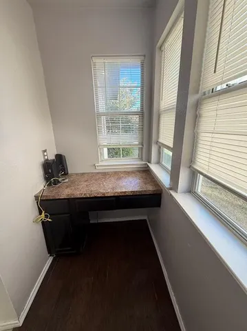 a view of a room with wooden floor and a ceiling fan
