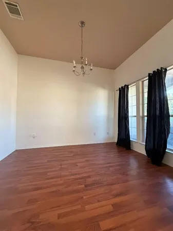 a view of a room with wooden floor and a window
