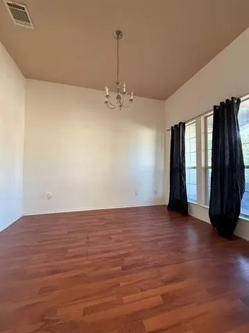 a view of a room with wooden floor and a window