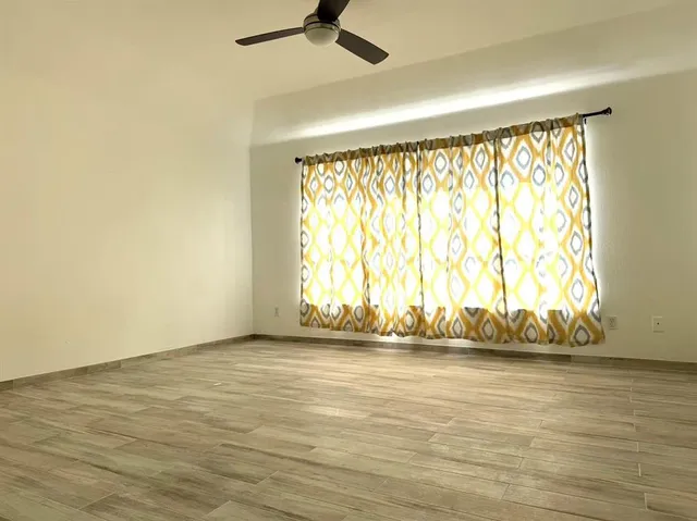 a view of a livingroom with a ceiling fan and wooden floor