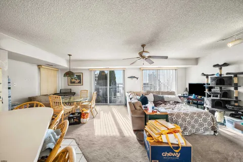 a living room with furniture a flat screen tv and a large window