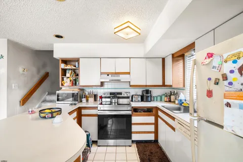 a kitchen with a sink a stove and cabinets