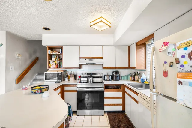 a kitchen with a sink a stove and cabinets