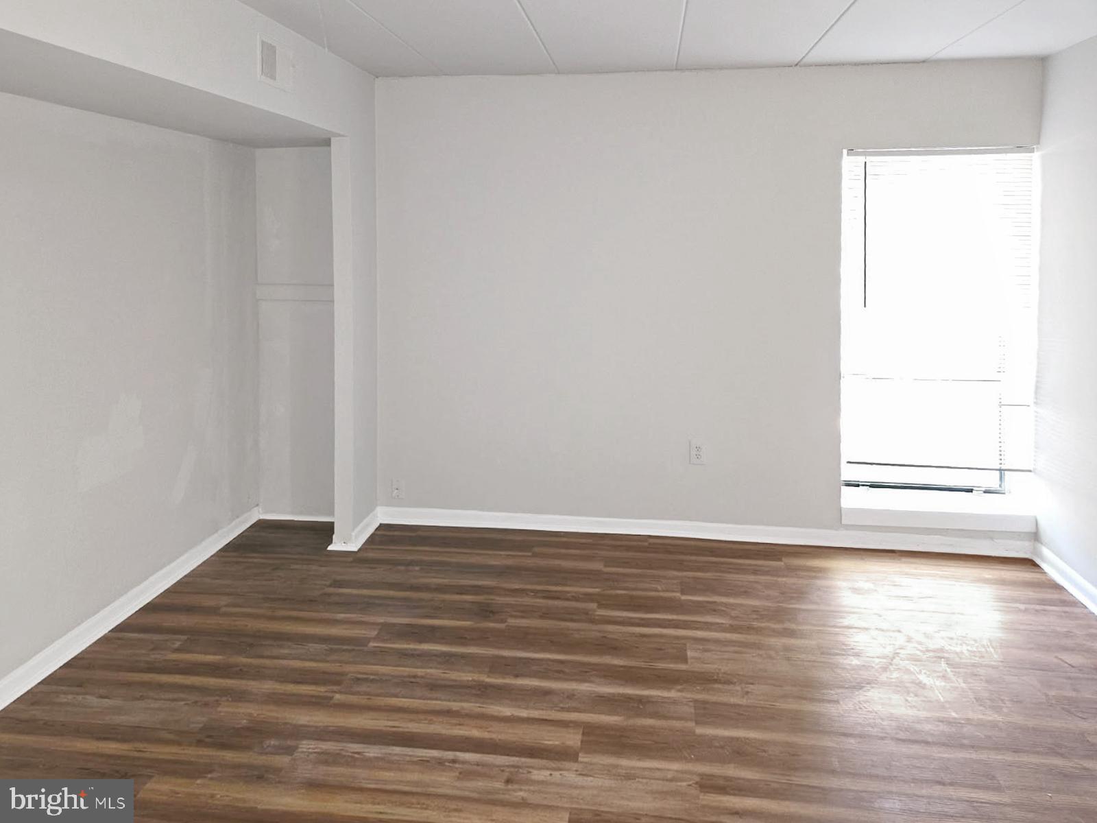 233 Township Line Road, Unit 2A Elkins Park, PA 19027 - Photo 15 of 24 a view of an empty room with wooden floor and a window