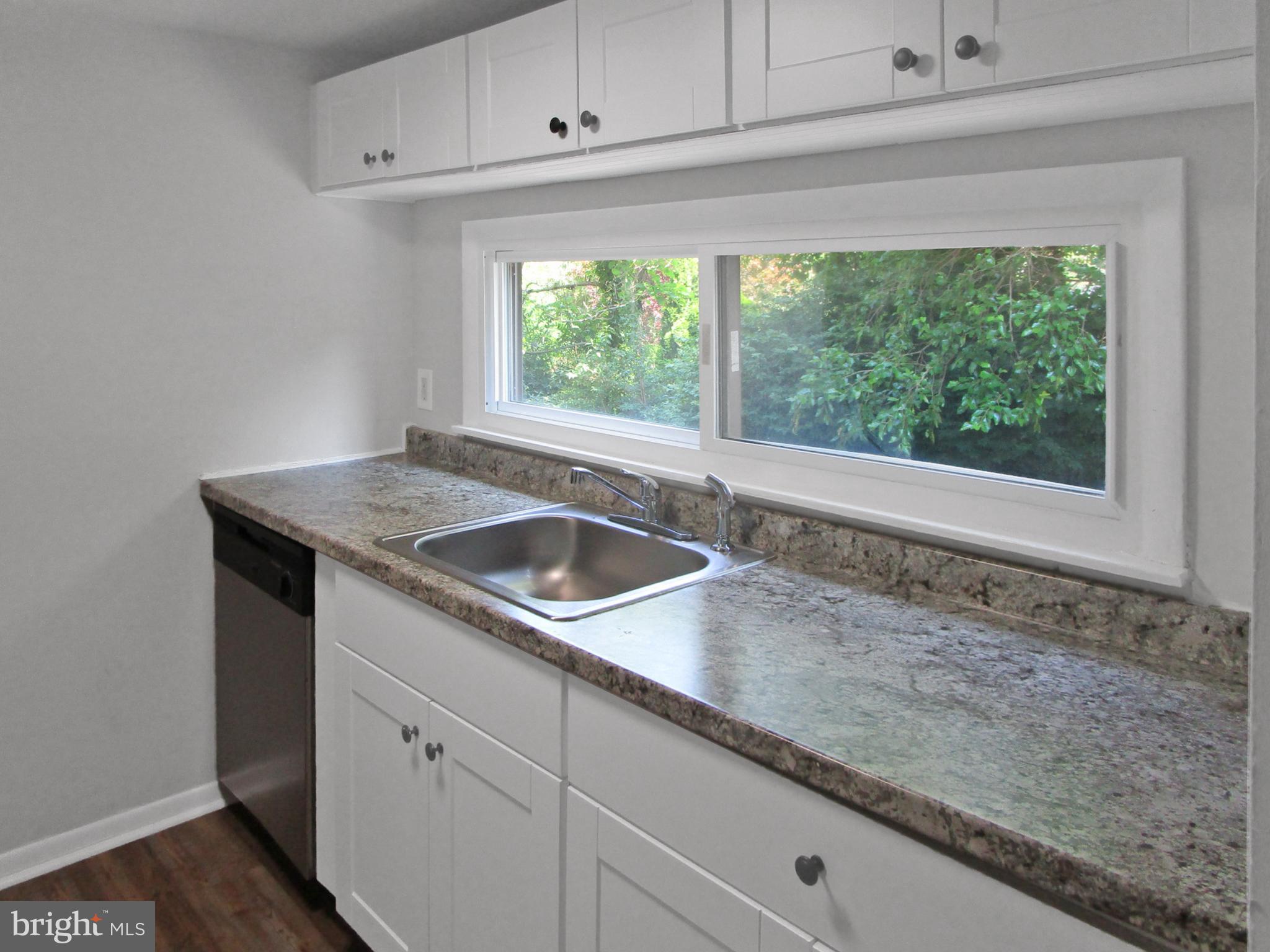 233 Township Line Road, Unit 2A Elkins Park, PA 19027 - Photo 7 of 24 a kitchen with granite countertop white cabinets and a sink