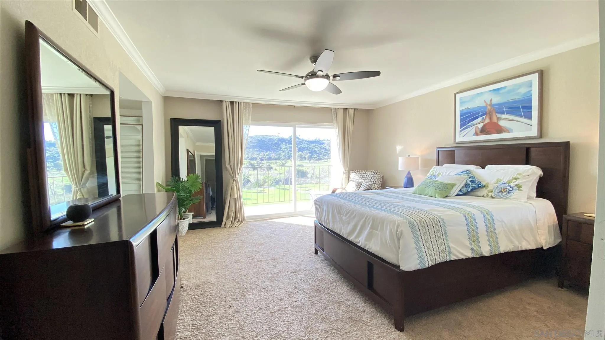 6780 Mission Gorge Road, Unit 30 San Diego, CA 92120 - Photo 13 of 24 a spacious bedroom with a large bed and a chandelier