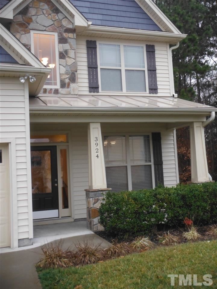 Covered front porch, accented with landscaping. Window panel in front door allows natural light into entry.