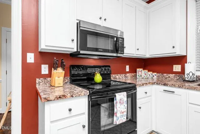 a kitchen with granite countertop a stove and a sink