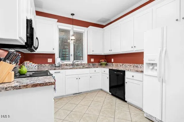 a kitchen with stainless steel appliances granite countertop a stove a sink and white cabinets