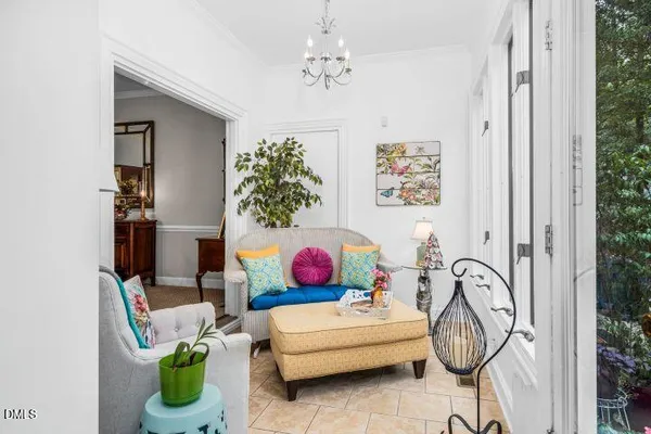 a living room with furniture flowers and a window