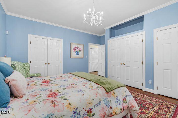 1311 Forest Hills Road Northwest, Unit D2 Wilson, NC 27896 - Photo 22 of 31 a bedroom with a large bed and a chandelier