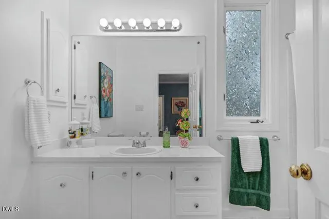a bathroom with a sink vanity and mirror