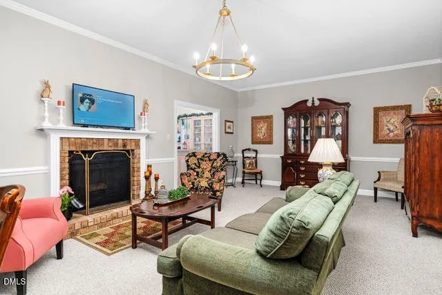 a living room with furniture a chandelier and a fireplace