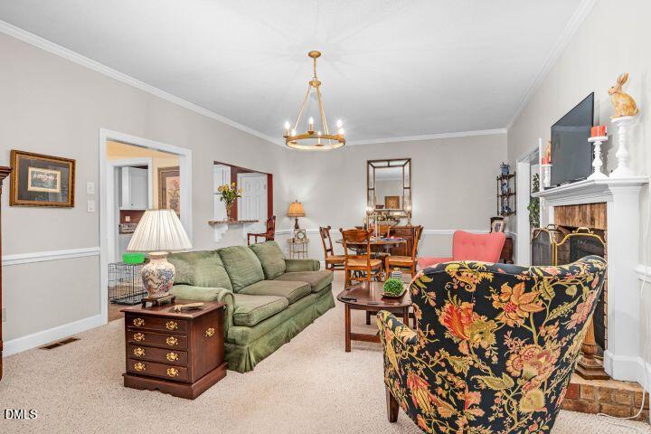 1311 Forest Hills Road Northwest, Unit D2 Wilson, NC 27896 - Photo 10 of 31 a living room with furniture a fireplace and a chandelier