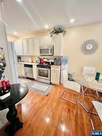 a kitchen with stainless steel appliances a stove a sink cabinets and wooden floor