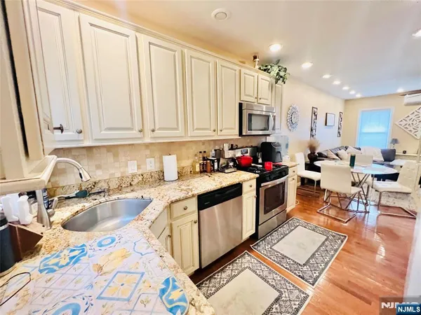 a kitchen with stainless steel appliances granite countertop a sink stove and cabinets