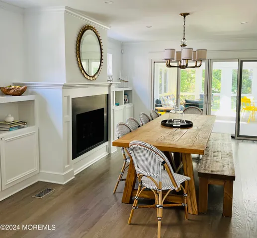 a dining room with furniture a fireplace and wooden floor