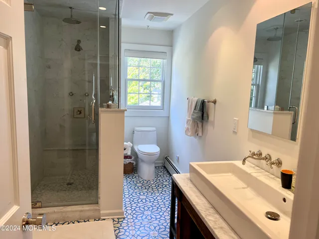 a bathroom with a sink a toilet and shower