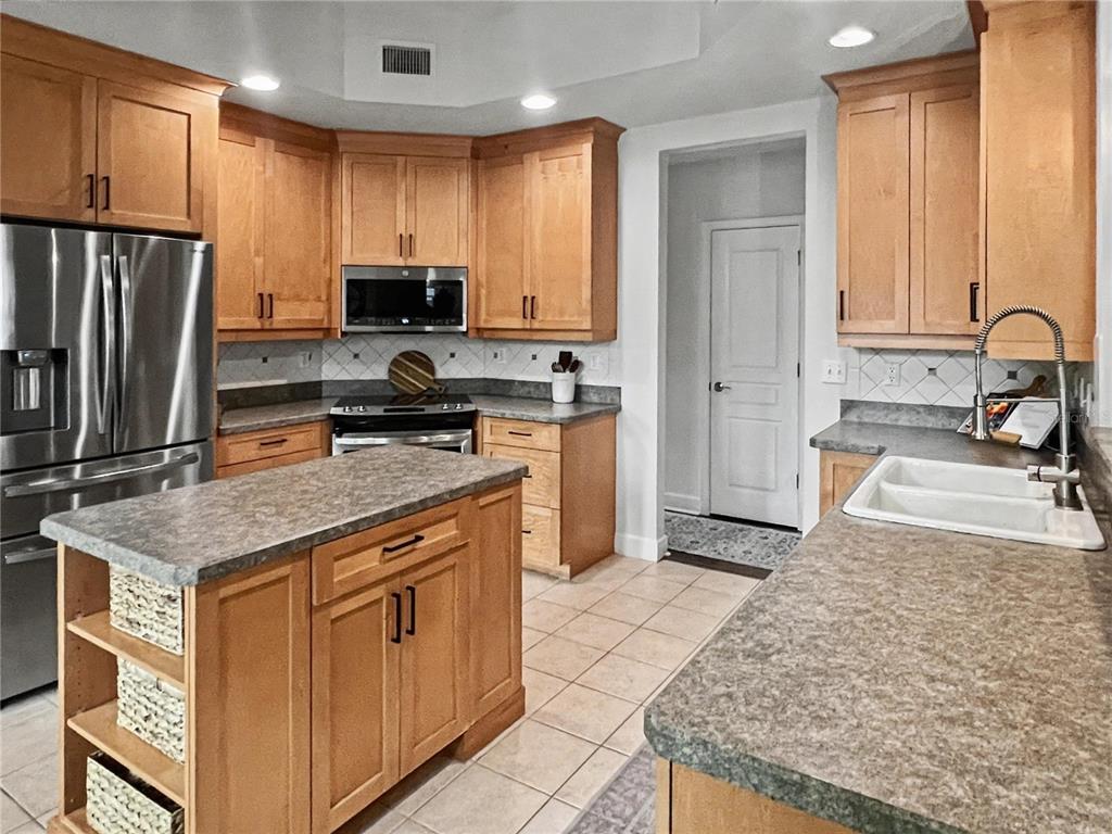 12912 Southwest 3rd Place Newberry, FL 32669 - Photo 9 of 38 a kitchen with stainless steel appliances granite countertop a sink stove and refrigerator