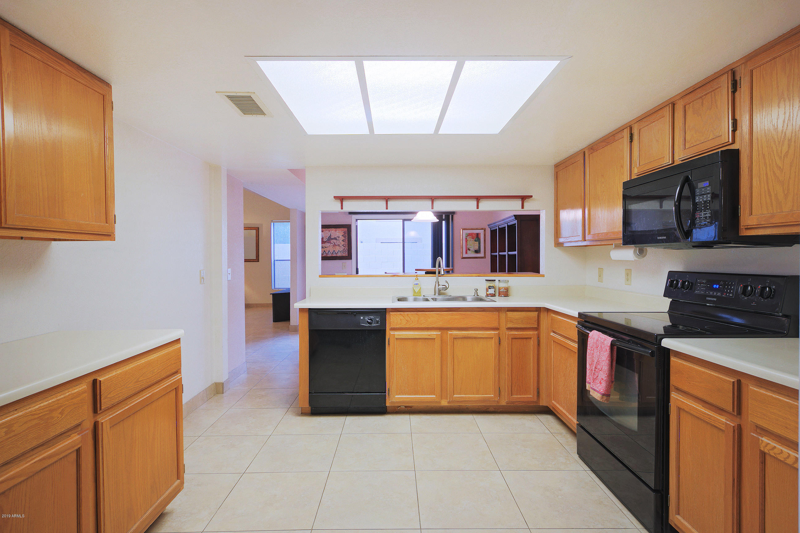 4217 East Agave Road Phoenix, AZ 85044 - Photo 11 of 20 a large kitchen with stainless steel appliances granite countertop a stove top oven a sink dishwasher a dining table and chairs with wooden floor