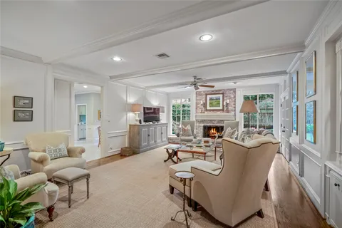 a living room with fireplace furniture and a large window